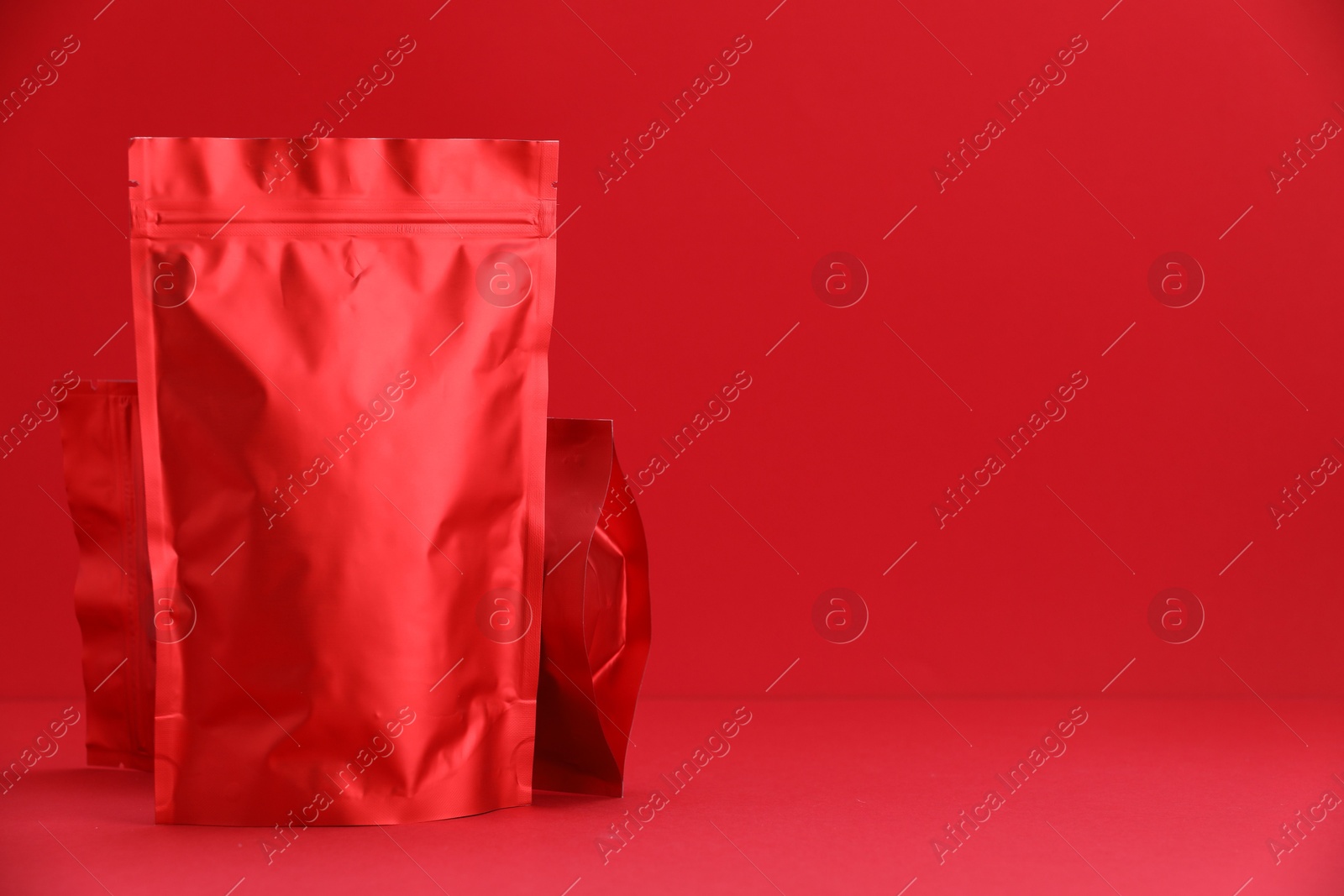 Zipper stand-up pouches on red background. Mockup for design Photo of Zipper stand-up pouches on red background. Mockup for design