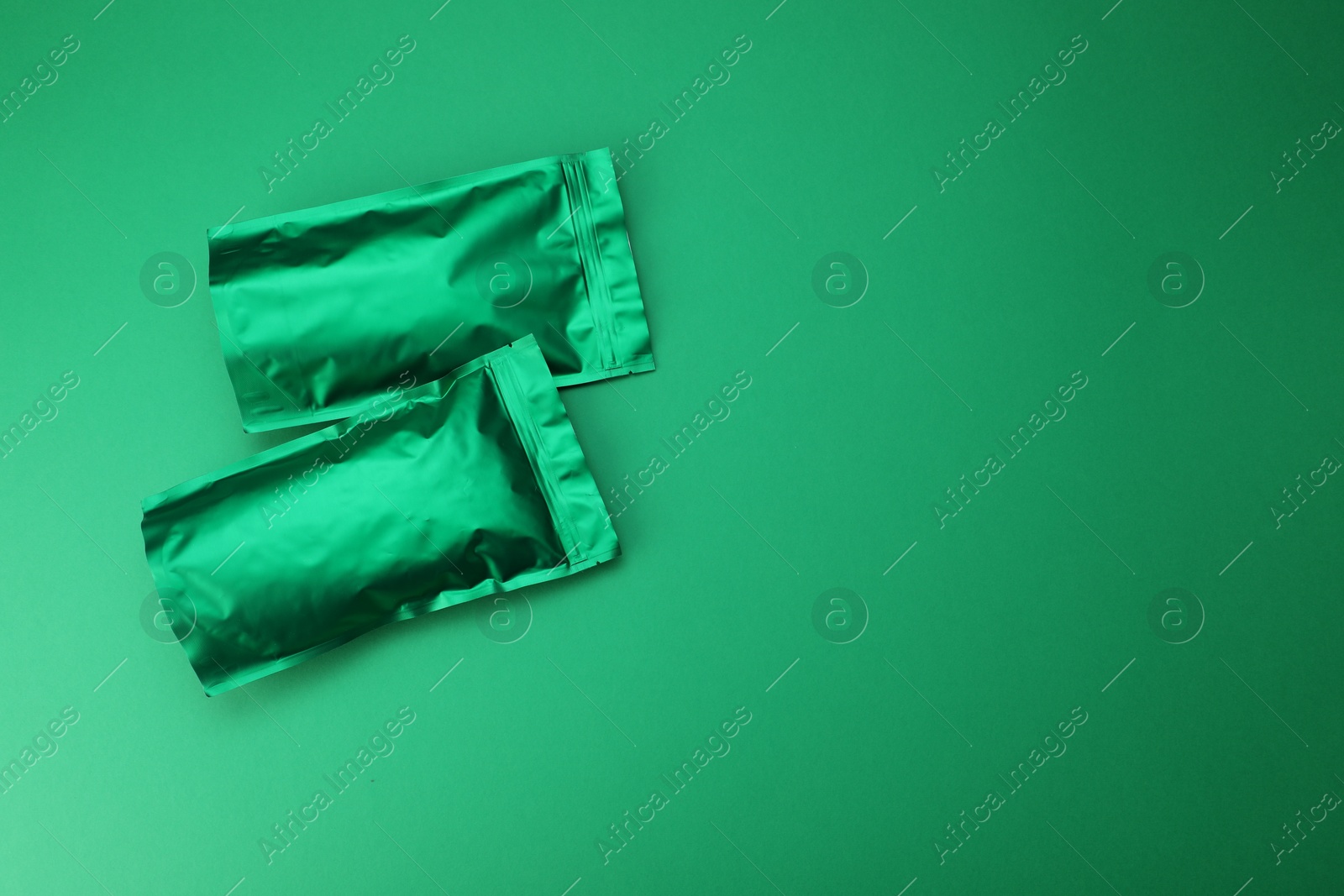Zipper stand-up pouches on green background, top view. Mockup for design Photo of Zipper stand-up pouches on green background, top view. Mockup for design