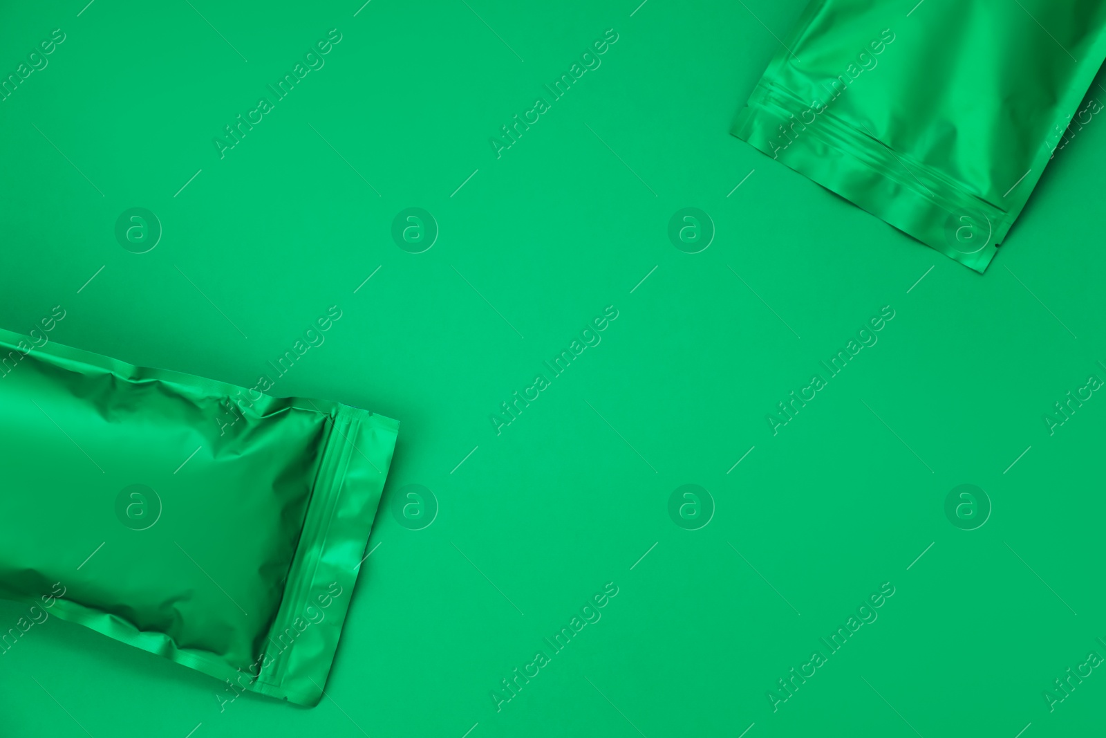 Zipper stand-up pouches on green background, top view. Mockup for design Photo of Zipper stand-up pouches on green background, top view. Mockup for design