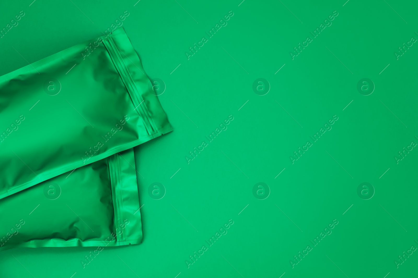 Zipper stand-up pouches on green background, top view. Mockup for design Photo of Zipper stand-up pouches on green background, top view. Mockup for design
