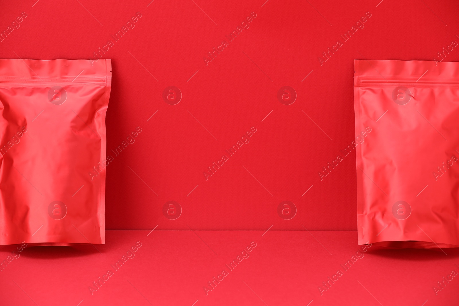 Zipper stand-up pouches on red background. Mockup for design Photo of Zipper stand-up pouches on red background. Mockup for design