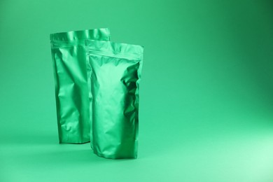 Photo of Zipper stand-up pouches on green background. Mockup for design