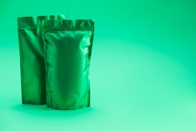 Photo of Zipper stand-up pouches on green background. Mockup for design