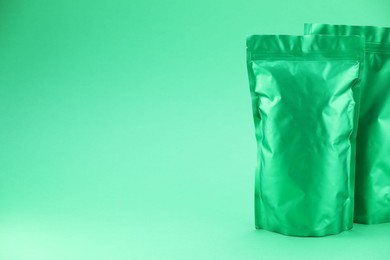 Photo of Zipper stand-up pouches on green background. Mockup for design