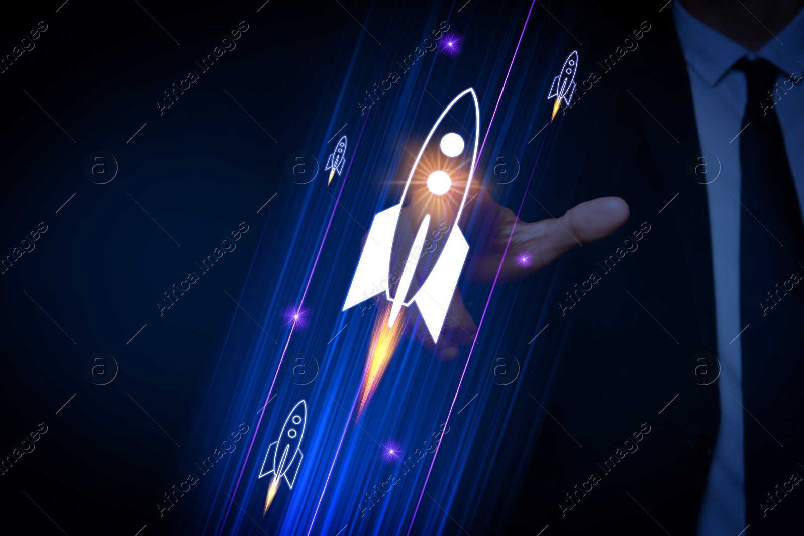Business, successful startup. Man launching rocket on virtual screen against dark blue background, closeup Image of Business, successful startup. Man launching rocket on virtual screen against dark blue background, closeup