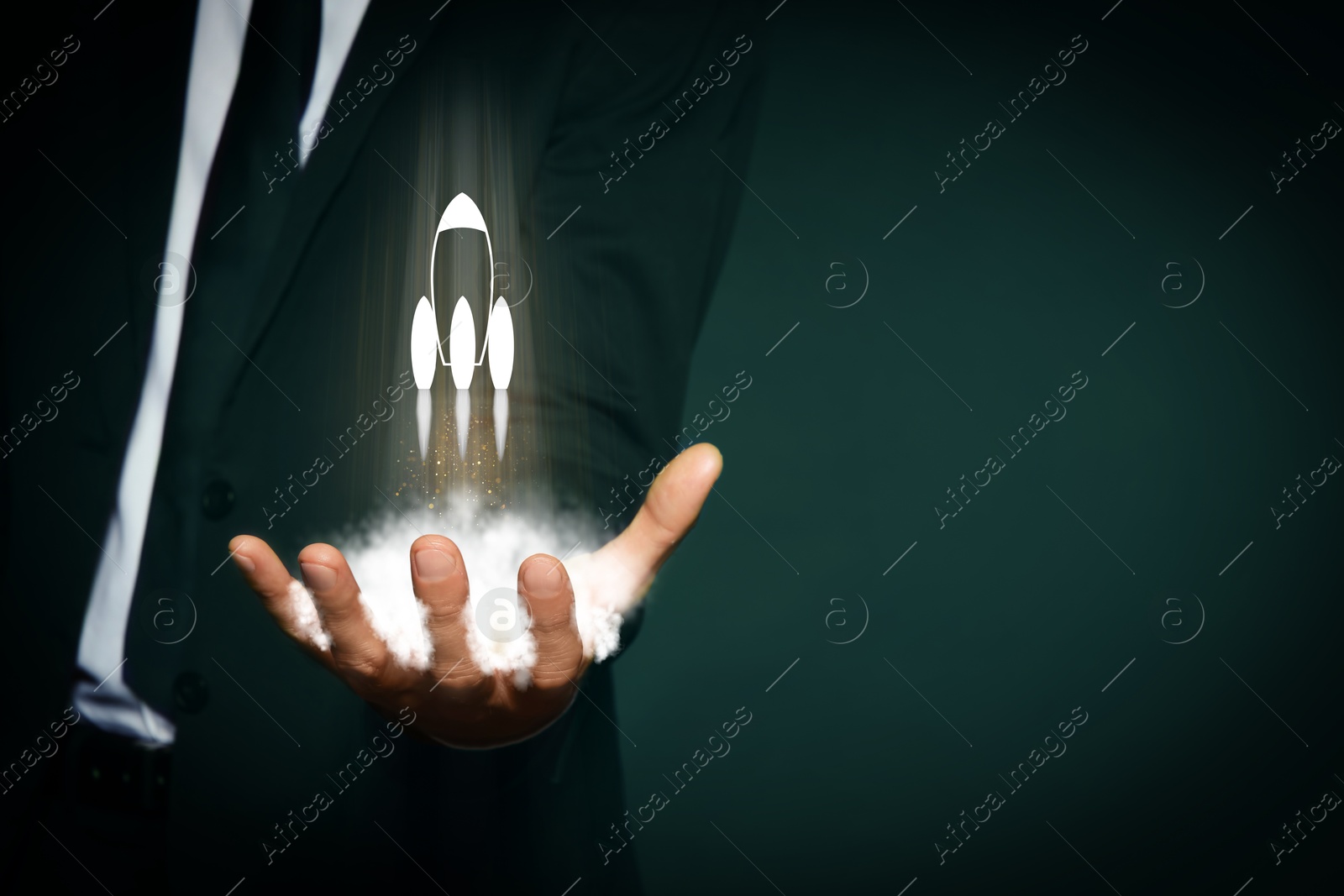 Business, successful startup. Man holding virtual rocket on against dark green background, closeup Image of Business, successful startup. Man holding virtual rocket on against dark green background, closeup