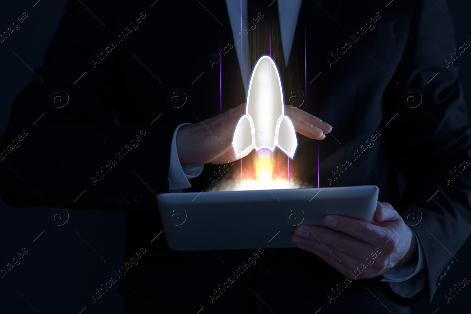 Business, successful startup. Man using tablet computer against dark background, closeup. Rocket launching from device Image of Business, successful startup. Man using tablet computer against dark background, closeup. Rocket launching from device
