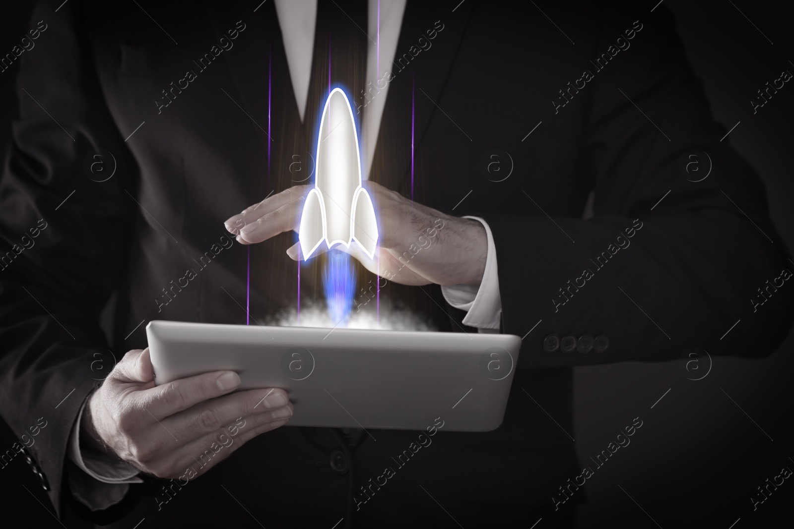 Business, successful startup. Man using tablet computer against dark background, closeup. Rocket launching from device Image of Business, successful startup. Man using tablet computer against dark background, closeup. Rocket launching from device