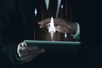 Image of Business, successful startup. Man using tablet computer against dark background, closeup. Rocket launching from device