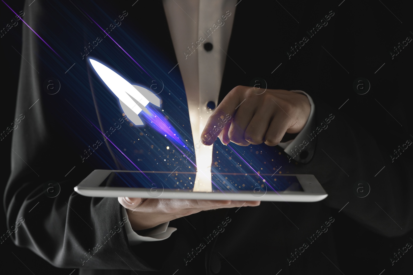 Business, successful startup. Man using tablet computer against dark background, closeup. Rocket launching from device Image of Business, successful startup. Man using tablet computer against dark background, closeup. Rocket launching from device
