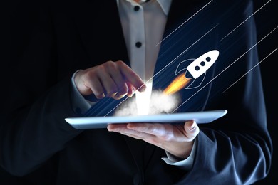Image of Business, successful startup. Man using tablet computer against dark background, closeup. Rocket launching from device