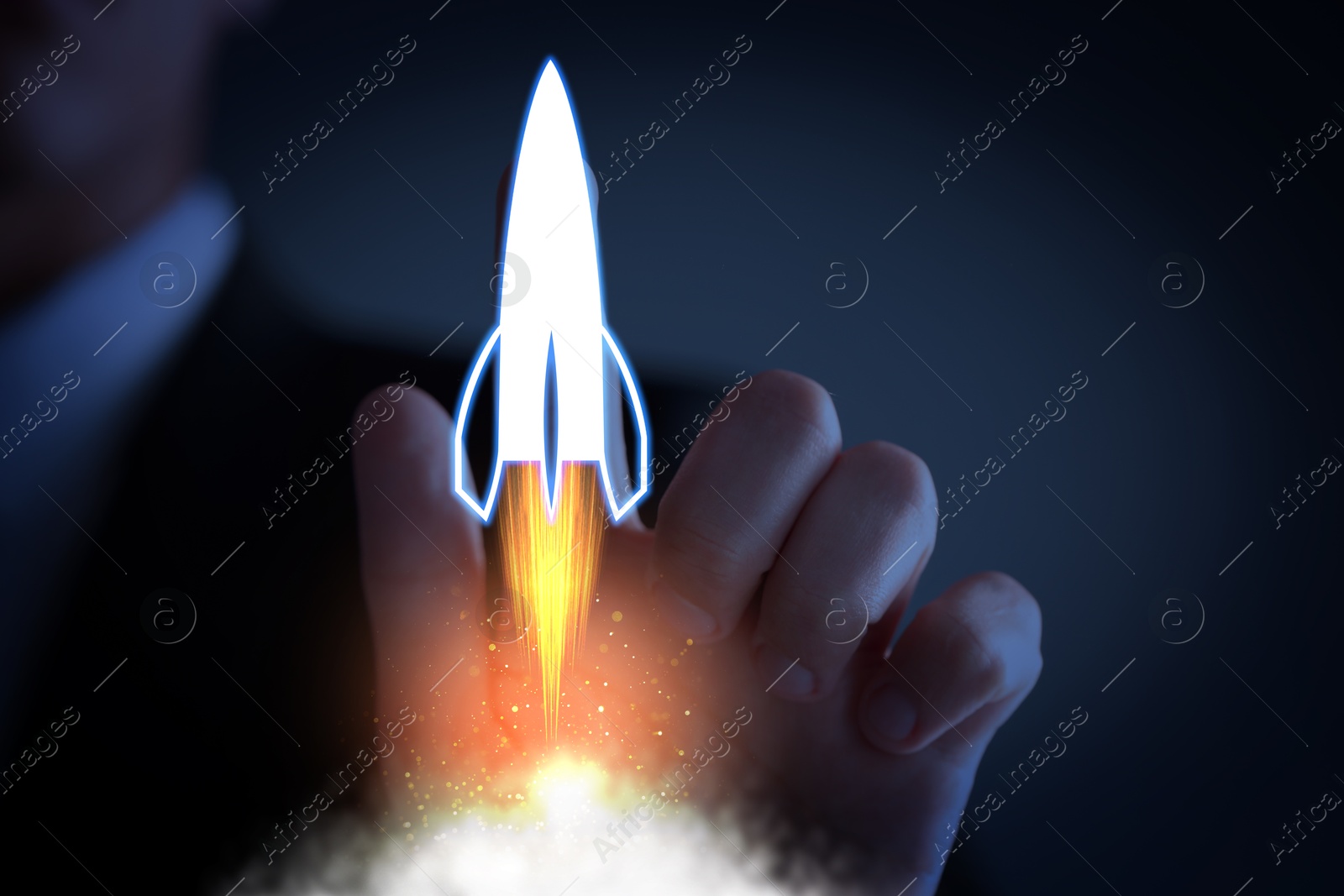 Business, successful startup. Man launching rocket on virtual screen against dark blue background, closeup Image of Business, successful startup. Man launching rocket on virtual screen against dark blue background, closeup