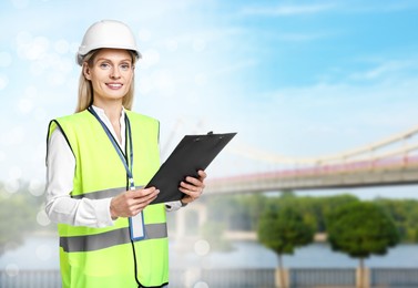 Image of Construction engineer with clipboard against bridge outdoors