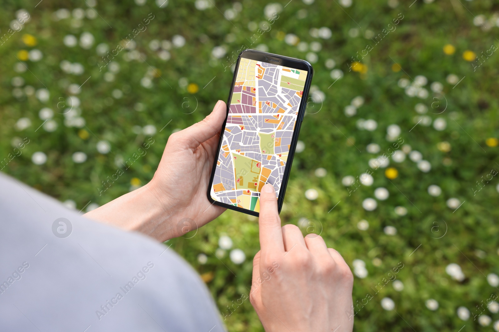 Woman looking at city map on her mobile phone outdoors, closeup Image of Woman looking at city map on her mobile phone outdoors, closeup