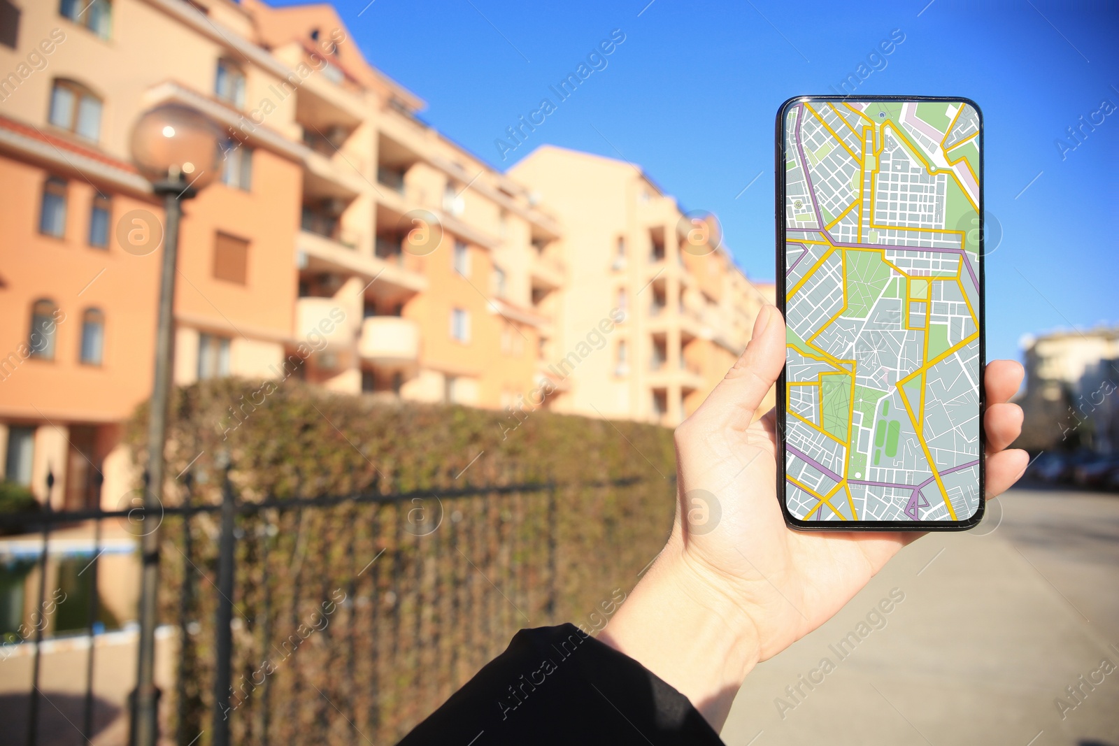 Man looking at city map on his mobile phone outdoors, closeup Image of Man looking at city map on his mobile phone outdoors, closeup