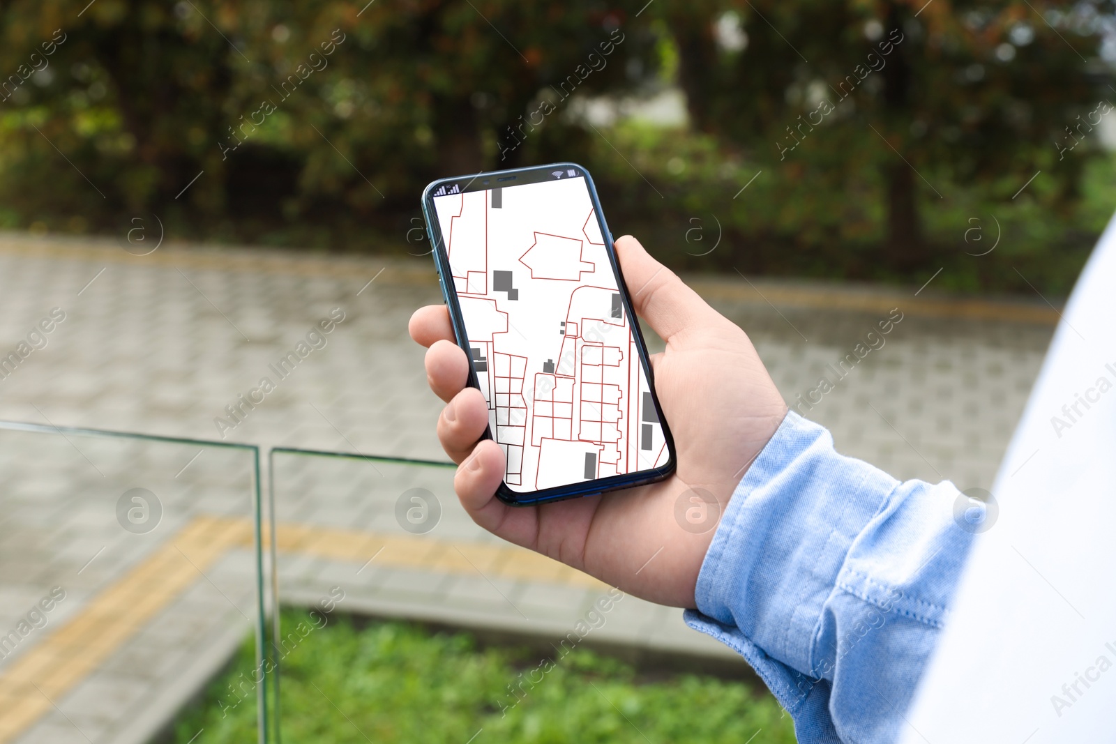 Man looking at city map on his mobile phone outdoors, closeup Image of Man looking at city map on his mobile phone outdoors, closeup