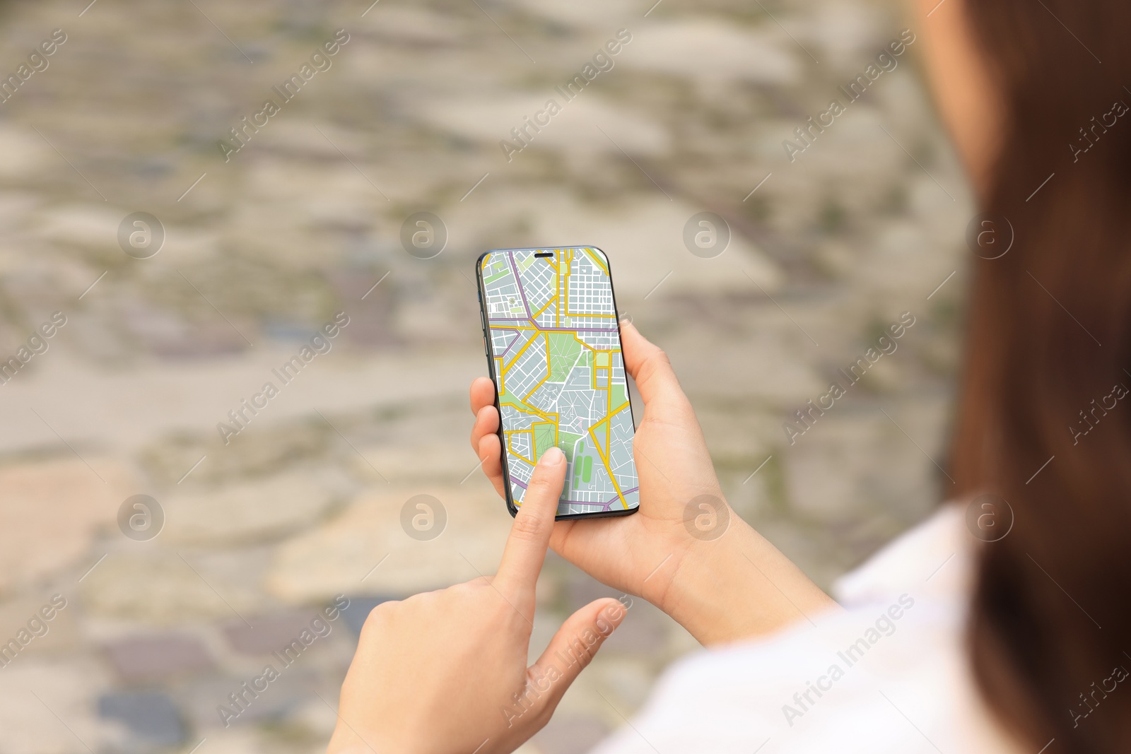 Woman looking at city map on her mobile phone outdoors, closeup Image of Woman looking at city map on her mobile phone outdoors, closeup