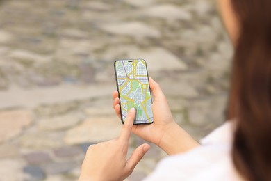 Image of Woman looking at city map on her mobile phone outdoors, closeup
