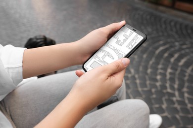 Image of Woman looking at city map on her mobile phone outdoors, closeup