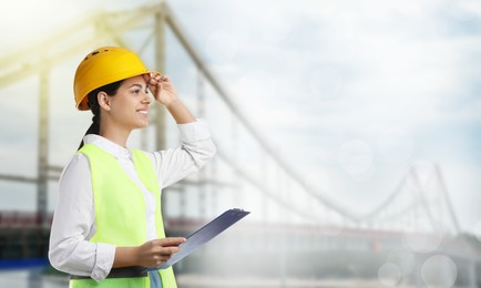 Image of Construction engineer with clipboard against bridge outdoors