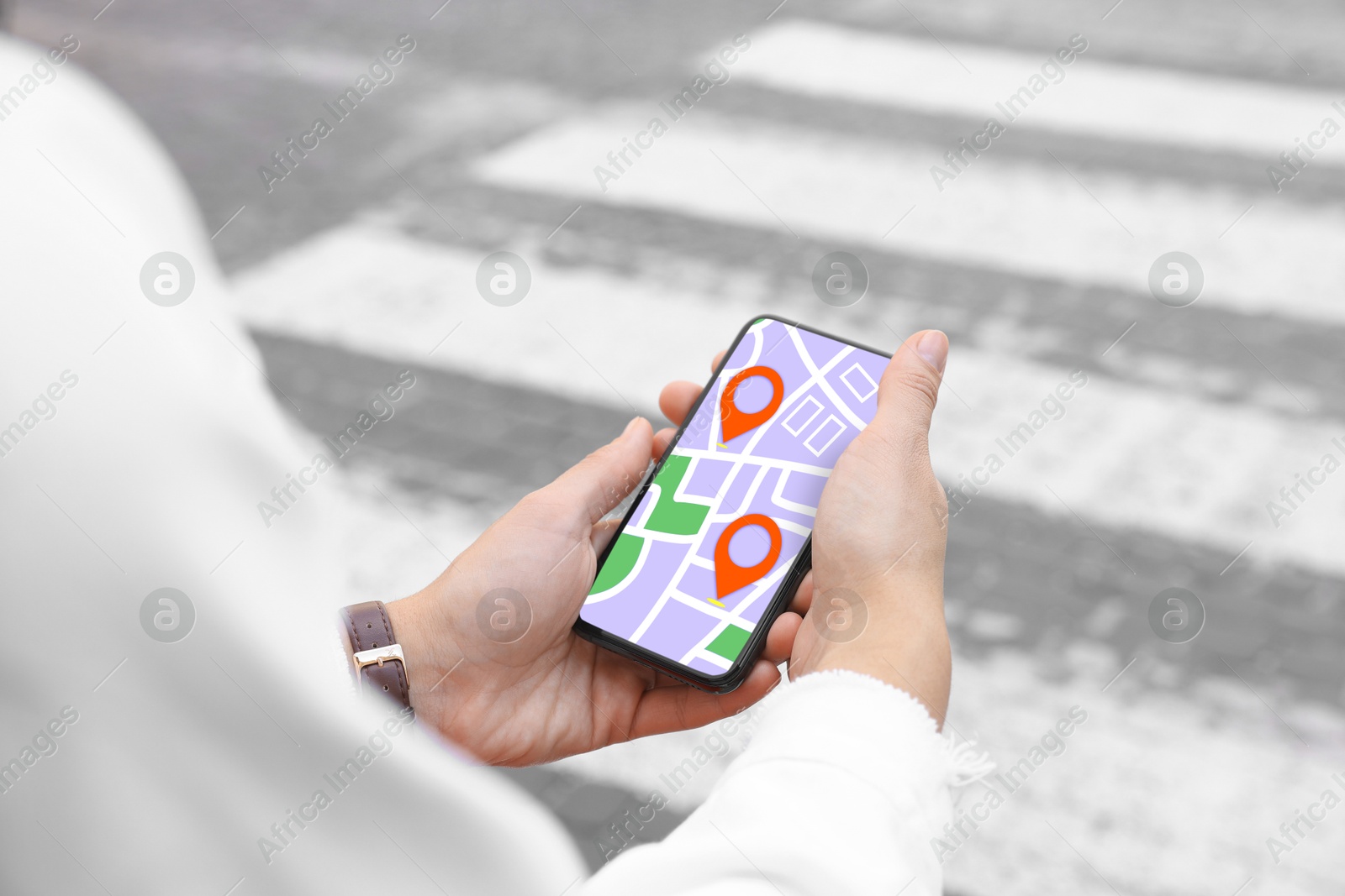 Image of Woman looking at city map on her mobile phone outdoors, closeup