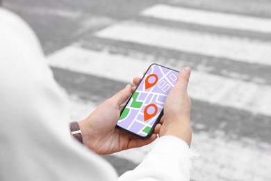 Image of Woman looking at city map on her mobile phone outdoors, closeup