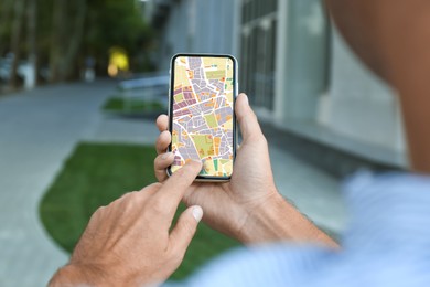 Image of Man looking at city map on his mobile phone outdoors, closeup