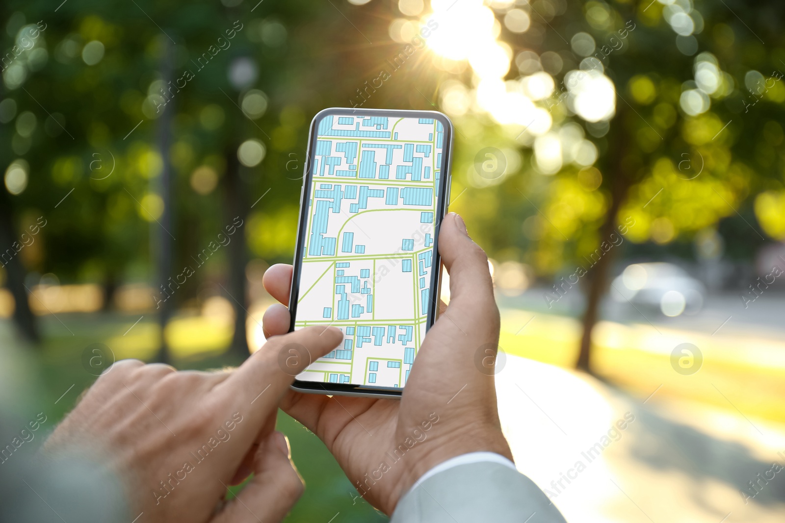 Man looking at city map on his mobile phone outdoors, closeup Image of Man looking at city map on his mobile phone outdoors, closeup
