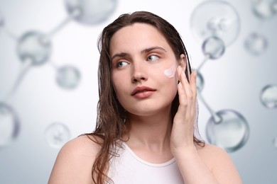 Image of Beautiful woman applying cream onto her face on light grey background with collagen molecules