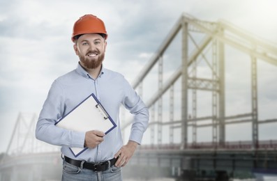 Image of Construction engineer with clipboard against bridge outdoors