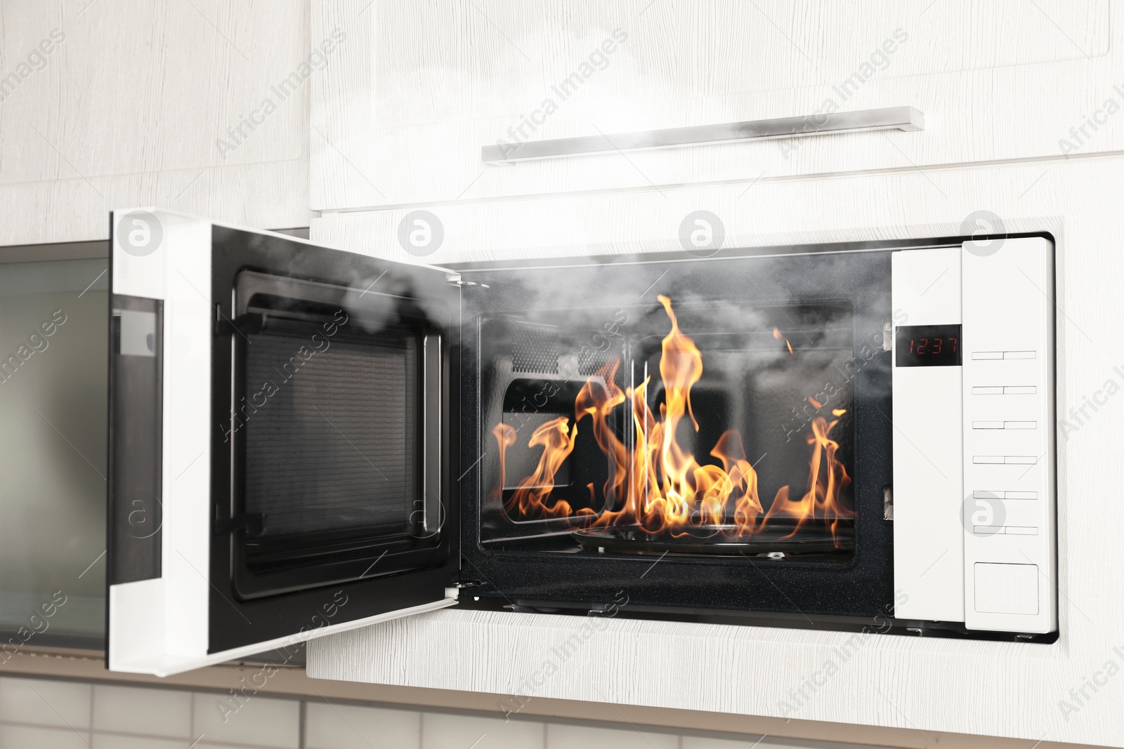 Fire and smoke in microwave oven in kitchen Image of Fire and smoke in microwave oven in kitchen