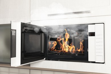 Image of Fire and smoke in microwave oven in kitchen