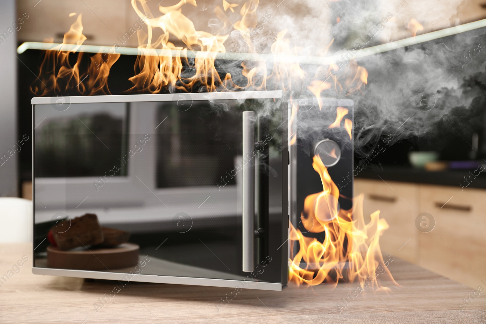 Image of Microwave oven burning inside on table in kitchen