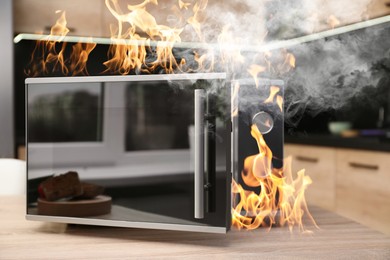 Image of Microwave oven burning inside on table in kitchen