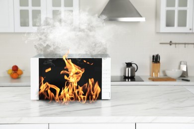 Image of Microwave oven burning inside on table in kitchen
