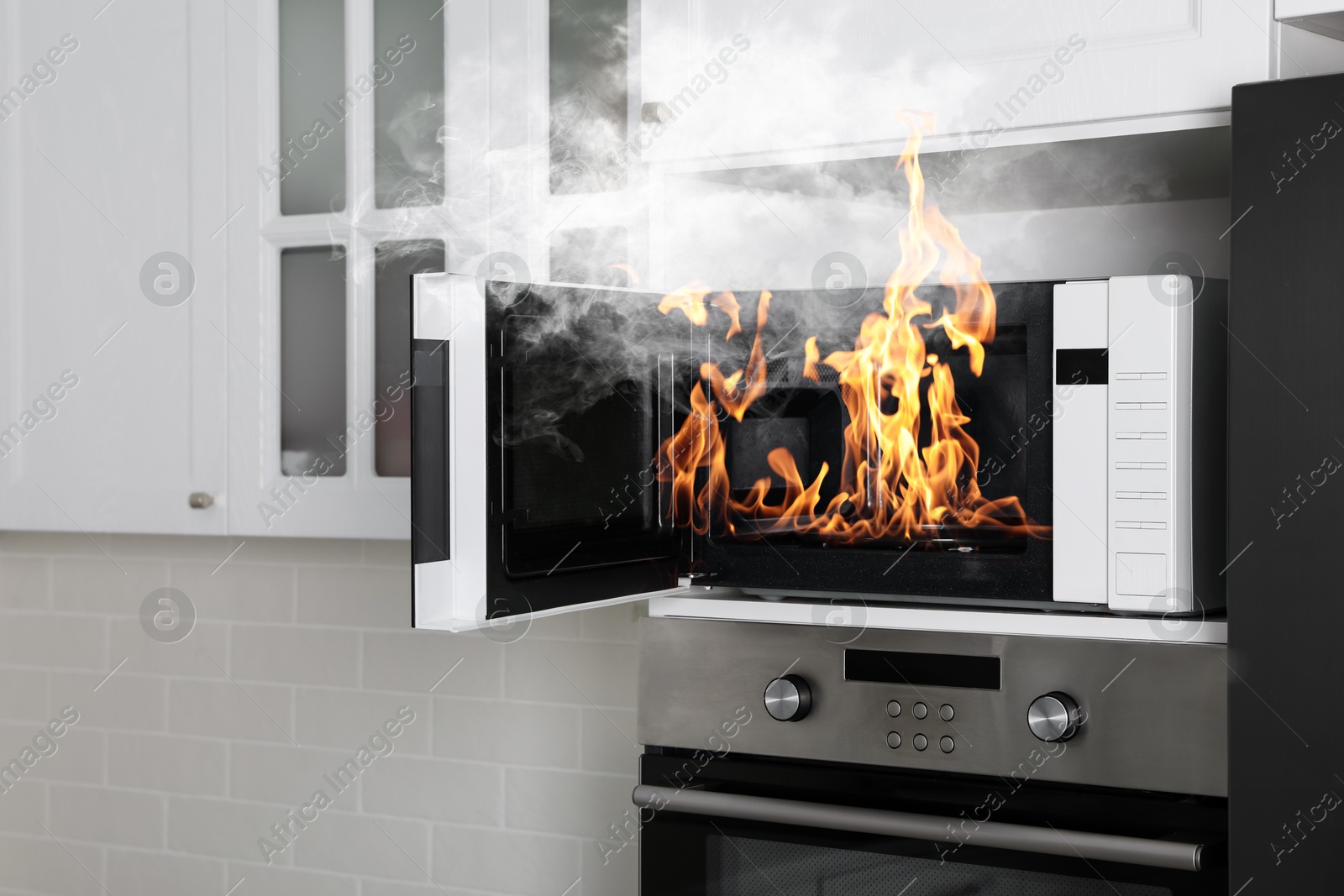 Fire and smoke in microwave oven in kitchen Image of Fire and smoke in microwave oven in kitchen