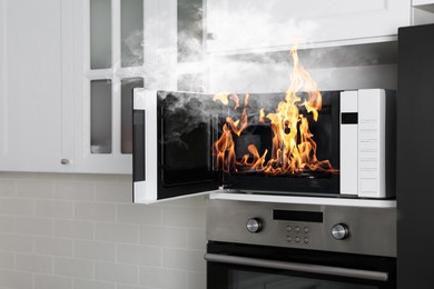 Image of Fire and smoke in microwave oven in kitchen