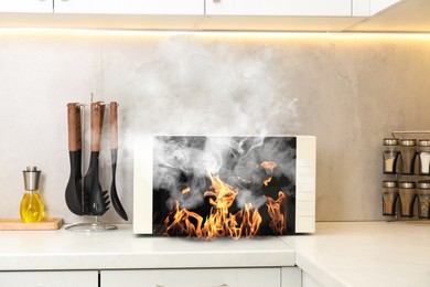 Image of Microwave oven burning inside on countertop in kitchen