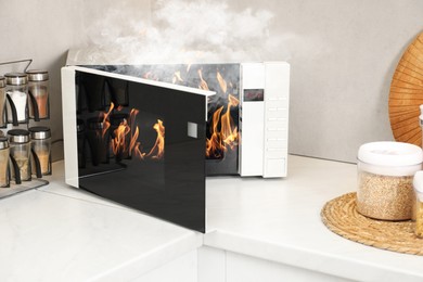 Image of Microwave oven burning inside on countertop in kitchen