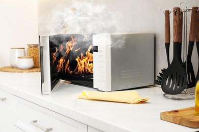 Image of Microwave oven burning inside on countertop in kitchen