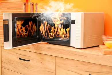 Image of Microwave oven burning inside on countertop in kitchen