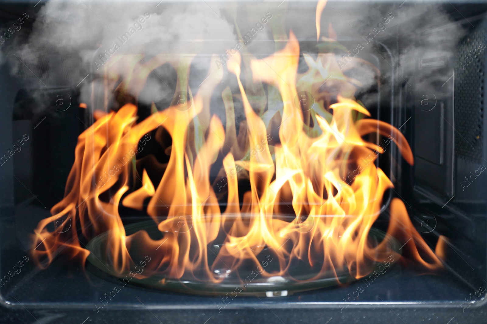 Fire and smoke in microwave oven, closeup Image of Fire and smoke in microwave oven, closeup