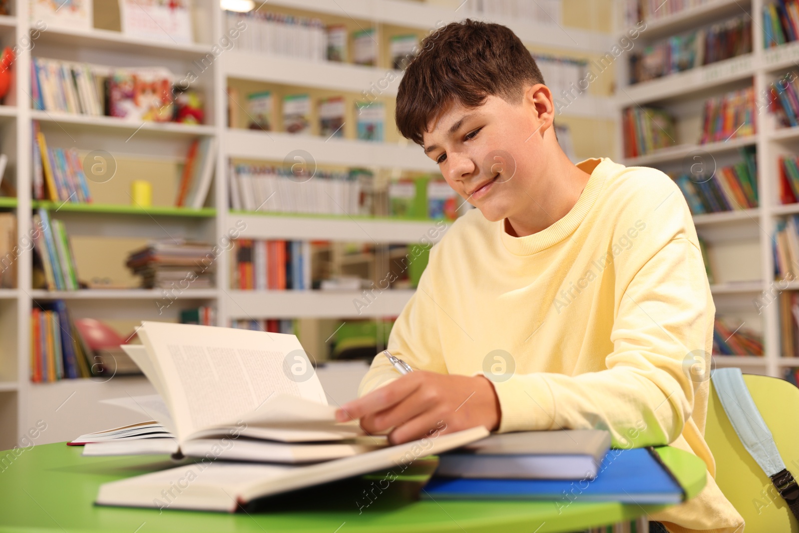 Student with books studying at table in library. Space for text Photo of Student with books studying at table in library. Space for text