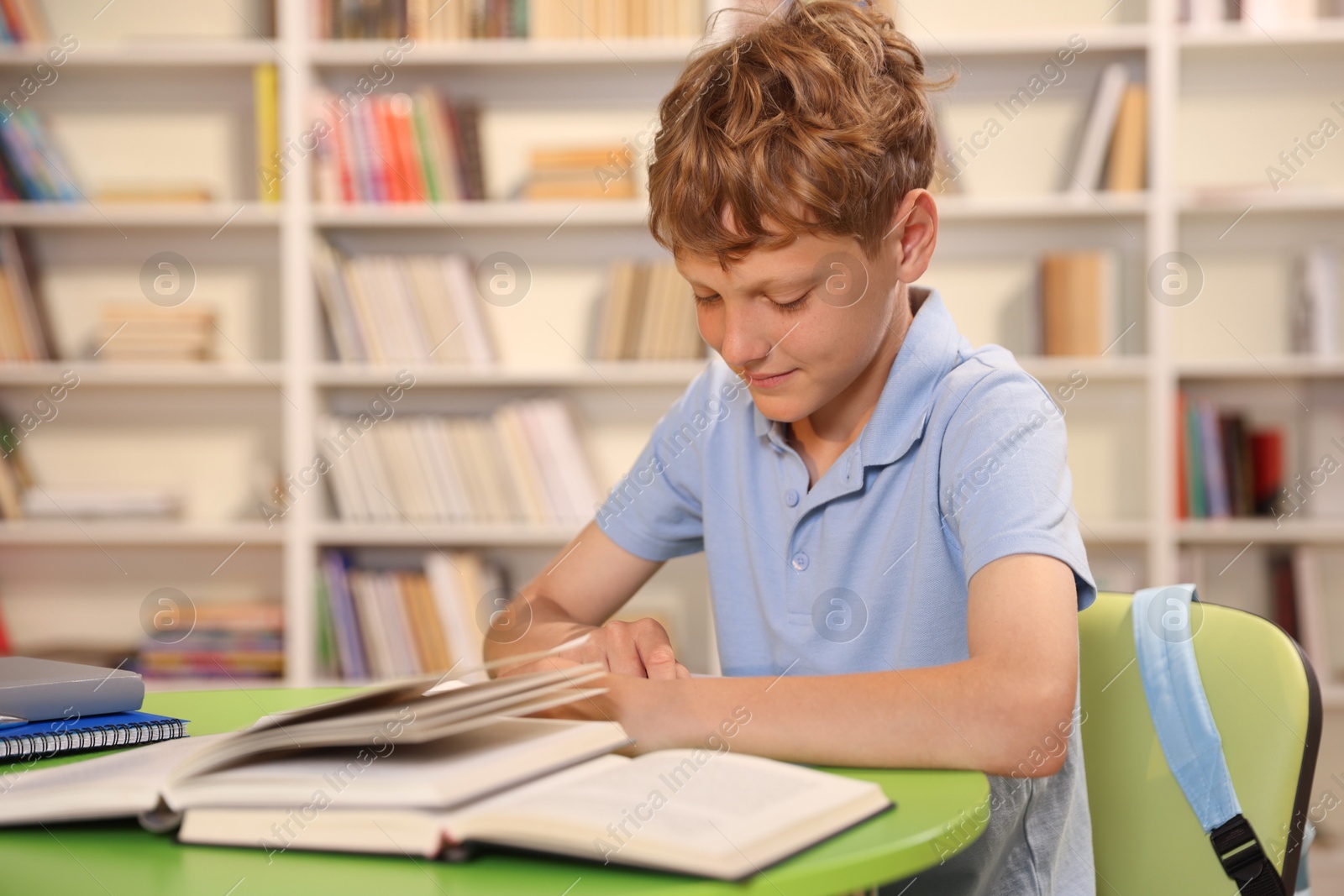 Student with books studying at table in library. Space for text Photo of Student with books studying at table in library. Space for text