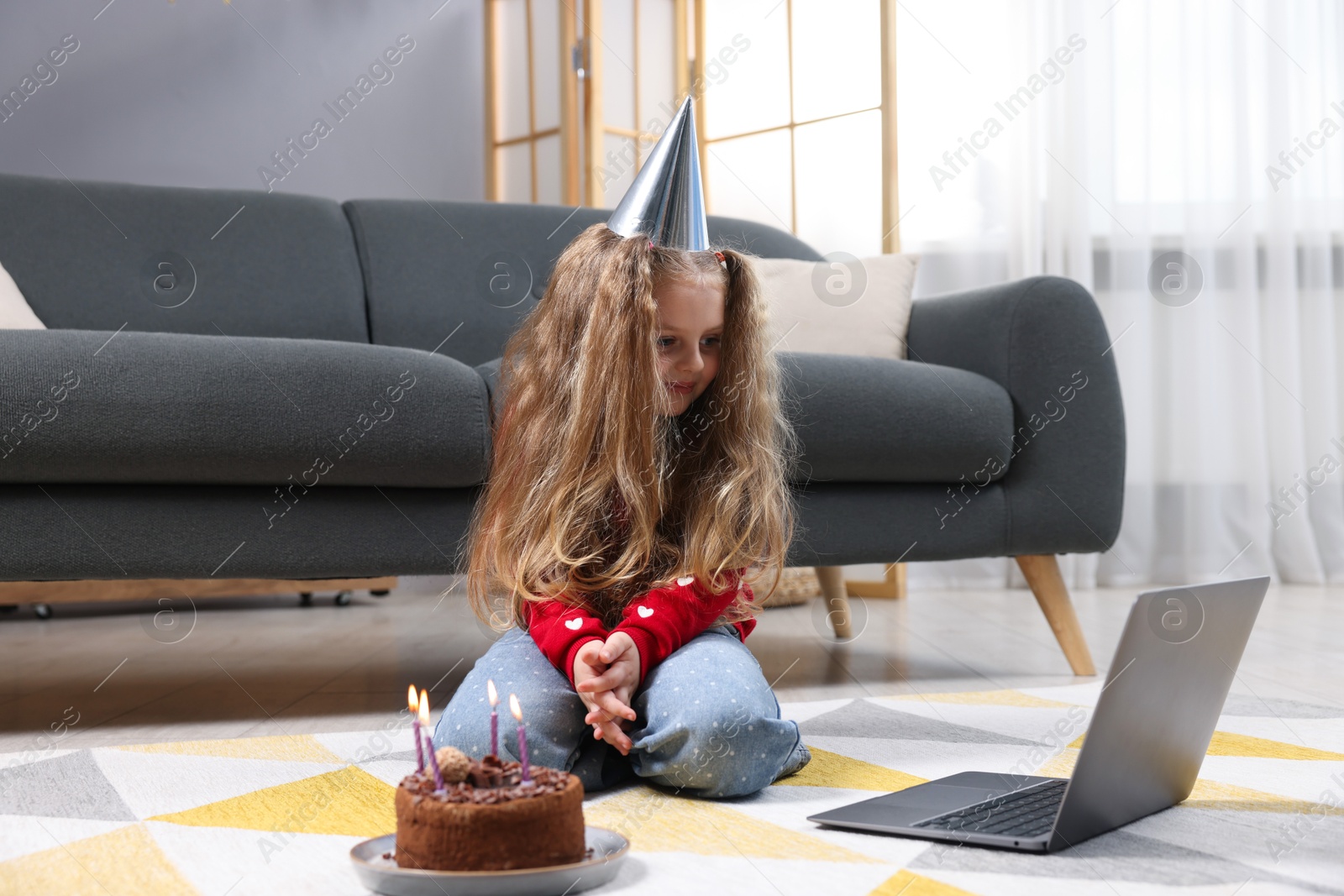 Birthday celebration. Little girl with cake having video call via laptop at home Photo of Birthday celebration. Little girl with cake having video call via laptop at home