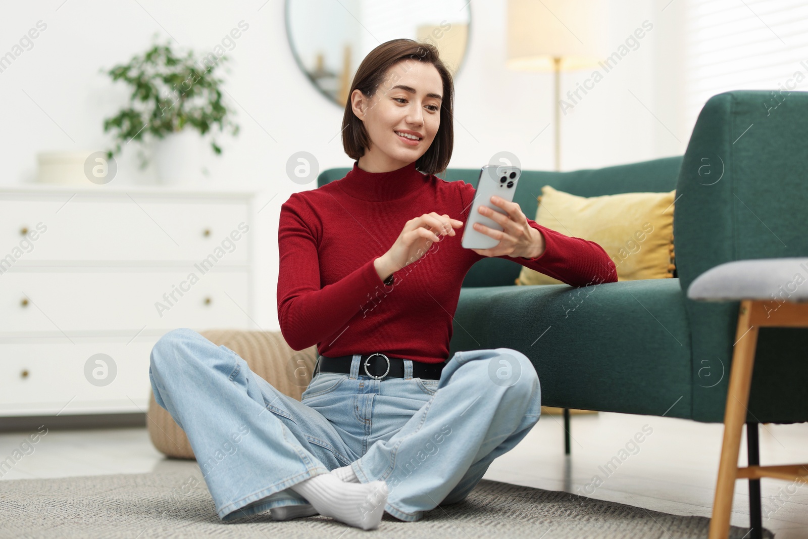 Woman using modern smartphone on floor at home Photo of Woman using modern smartphone on floor at home