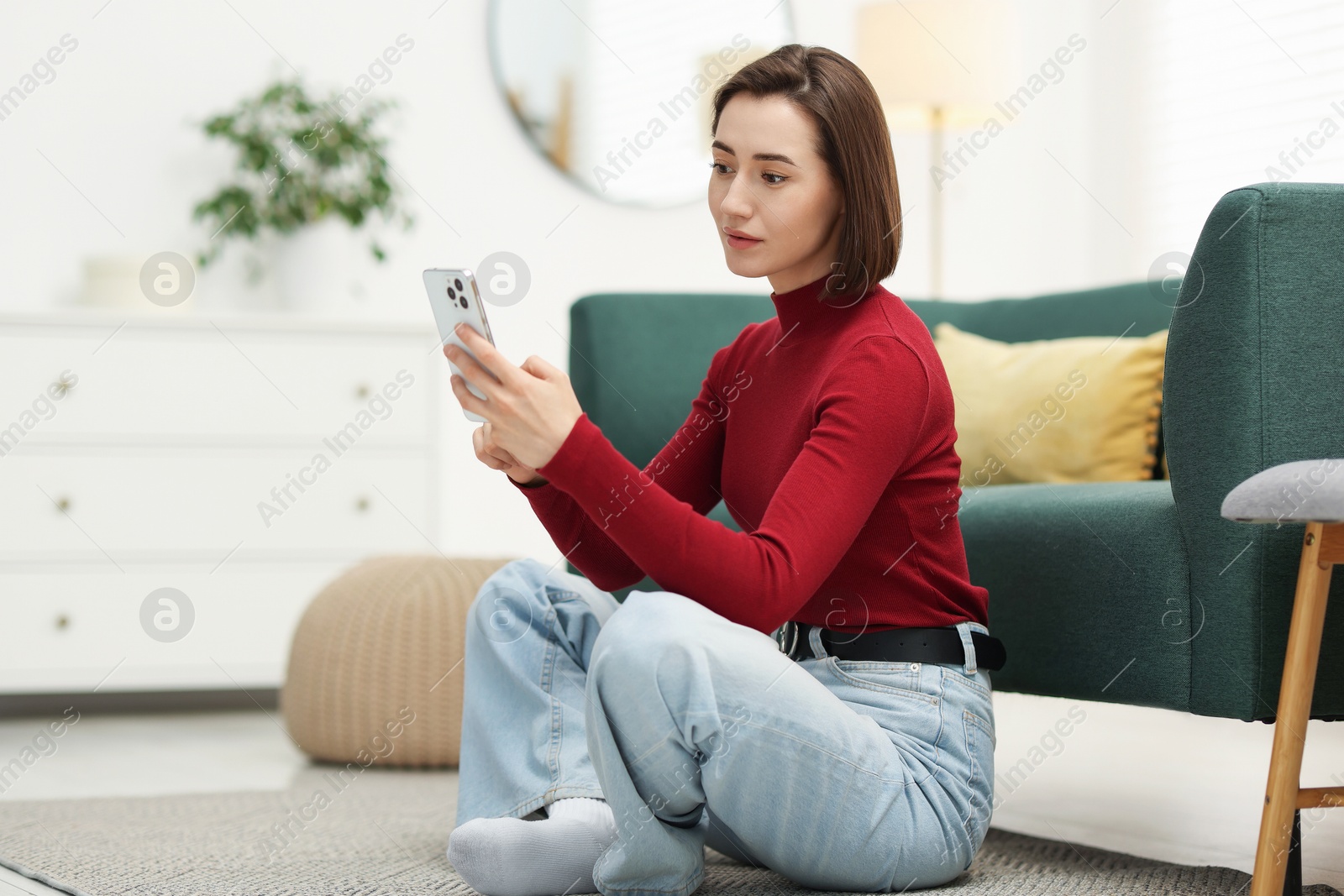 Woman using modern smartphone on floor at home Photo of Woman using modern smartphone on floor at home