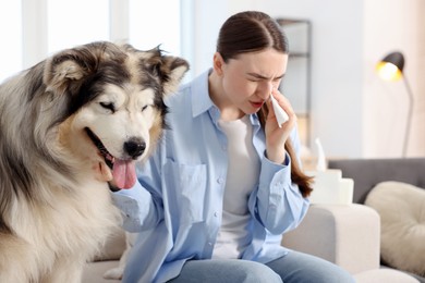 Photo of Woman suffering from allergy with her dog at home
