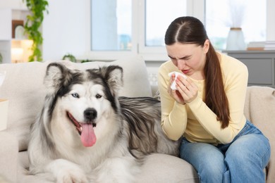 Photo of Woman suffering from allergy with her dog at home