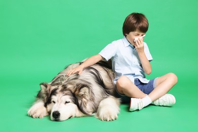 Photo of Boy suffering from allergy with her dog on green background. Space for text